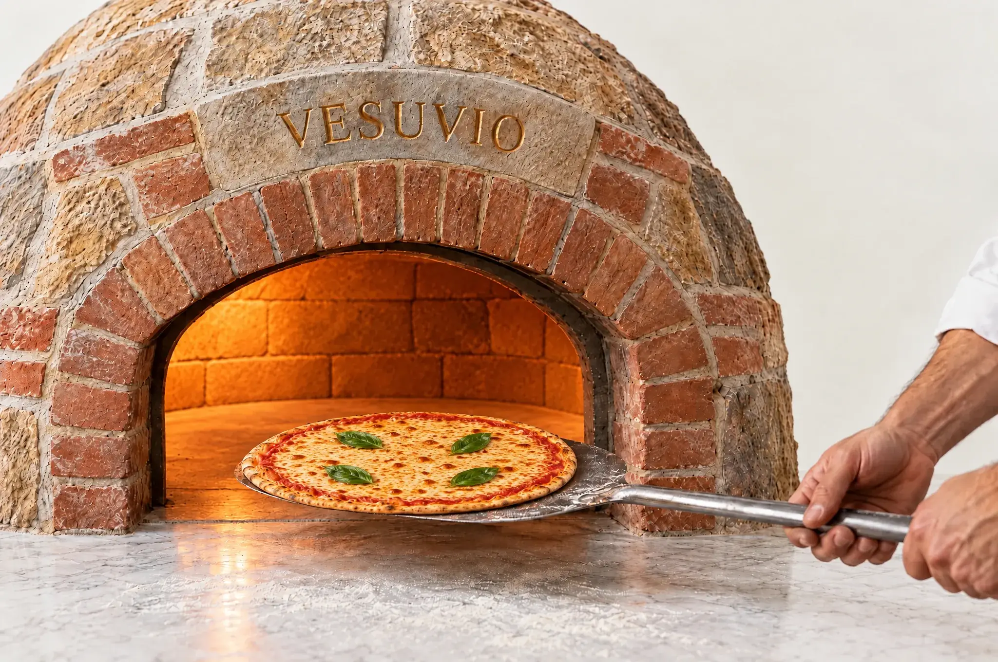 Eine Pizza mit goldbraun geschmolzenem Käse wird mit der Schaufel aus dem Steinofen geholt